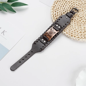 Detail of wide brown leather bracelet featuring bronze battle-axe and shield emblem