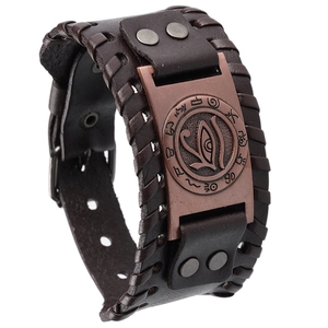 Macro detail of vintage leather bracelet showing Eye of Horus emblem and woven edges
