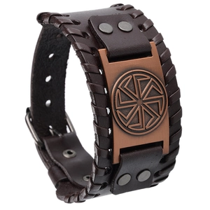 Detail of vintage brown leather bracelet featuring an engraved bronze Slavic sun wheel
