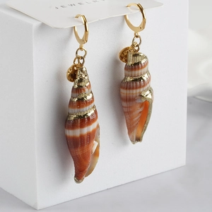 Elegant conch shell earrings with gold accents on a minimalist white display