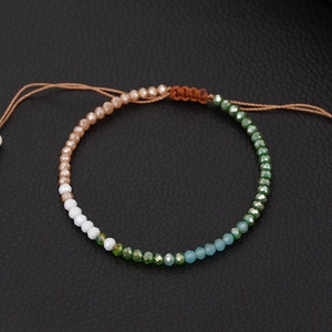 Detail of faceted glass beads and adjustable woven cord on a handmade bracelet