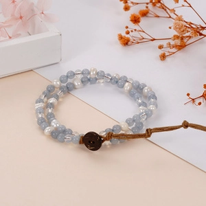 Detail of bohemian double-layer beaded bracelet with blue glass, pearls and button closure