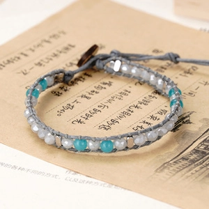 Detail view of handmade braided leather bracelet with agate beads and wooden button closure