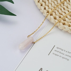 Minimalist gold titanium necklace featuring a cylindrical pink crystal prism pendant