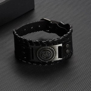 Détail d'un bracelet en cuir noir arborant un emblème vintage de l'US Marine Corps