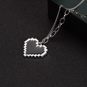 Y2K pixel heart pendant necklace with black enamel inlay on dark textured background