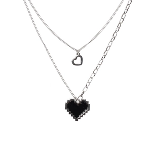 Close-up of double-layered silver chain necklace with black mosaic pixel heart pendant