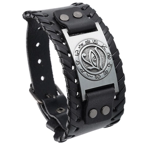 Détail d'un bracelet en cuir vintage avec plaque en métal Œil d'Horus et bords tressés