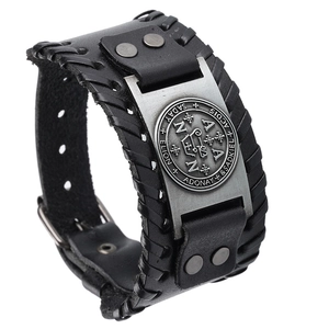 Détail du bracelet vintage en cuir noir avec plaque en métal argenté et rivets de fixation