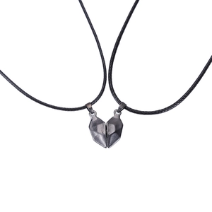 Détail de pendentifs cœur magnétiques noirs avec cordon tressé pour couples
