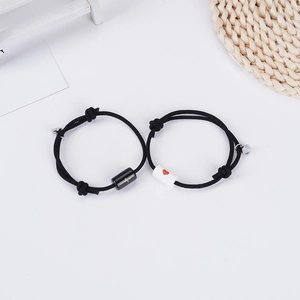 Matching magnetic couple bracelets with heartbeat and heart charms on woven rope