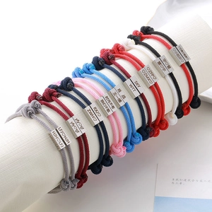 Close-up of hand-woven cord bracelets with custom engraved stainless steel plates