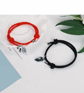 Detail of magnetic heart charms on adjustable woven rope bracelets for couples