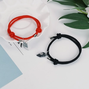 Magnetic heart couple bracelets with black and red braided cords and adjustable knots