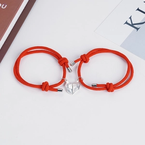 Matching magnetic heart couple bracelets in red woven rope with silver pendants
