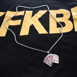 Close-up of royal flush poker pendant in silver stainless steel with red enamel accents