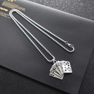 Detail of royal flush poker pendant on silver chain over a textured black background