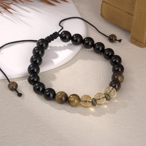 Detail of beaded energy bracelet with citrine and hematite on a white display stand