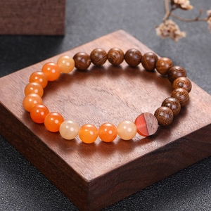 Détail macro du bracelet en perles de bois de wengé et pierres d'agate orange avec finitions
