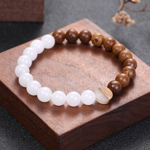 Bracelet zen en bois d'aile de poulet et perles de pierre blanche sur socle en bois