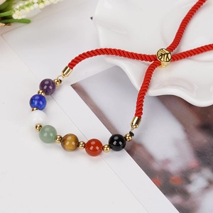 Bracelet tressé rouge avec pierres sept chakras et breloque dorée arbre de vie
