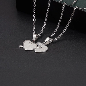 Macro shot of silver stainless steel heart puzzle pendants with engraved love quotes