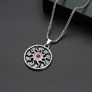 Detail of square twist chain necklace featuring a red gemstone sunburst pendant charm