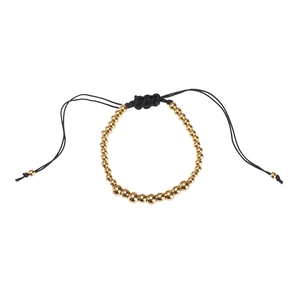 Detail of adjustable black woven cord bracelet with polished gold-plated gradient beads