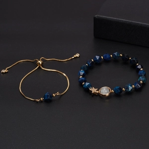 Luxury blue gemstone couple bracelets with golden star and planet charms on black background