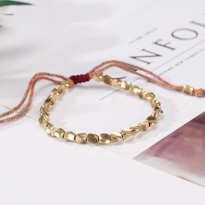Pulsera de pareja tejida a mano con cuentas doradas irregulares y cierre de borla ajustable