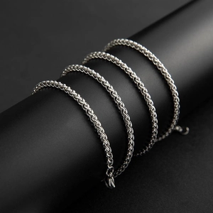 Collana a catena a spiga in acciaio al titanio argento lucido su supporto nero