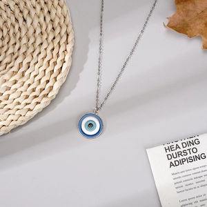 Detailansicht des türkischen Evil Eye Anhängers mit Silberkette auf neutralem Hintergrund