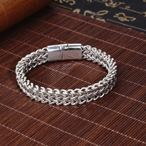 Mens double-row titanium steel bracelet with magnetic clasp on a brown bamboo background