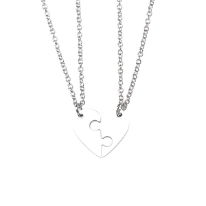 Detail of interlocking heart puzzle pendants on polished silver chains for couples