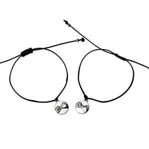Detail of adjustable couple bracelets featuring a silver pinky swear promise charm