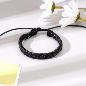 Detail of black braided leather bracelet with adjustable cord on white background