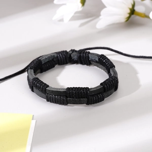Gros plan d'un bracelet en cuir tressé noir avec un cordon de serrage réglable vintage