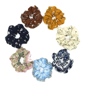 Set of 7 floral and bohemian fabric scrunchies in assorted vibrant colors on white background