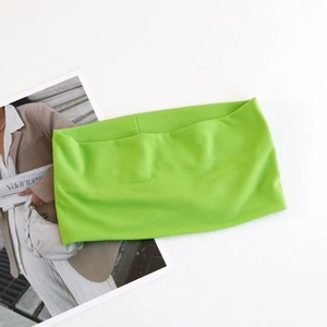 Flat lay of neon green elastic yoga headband on a magazine background with knit texture