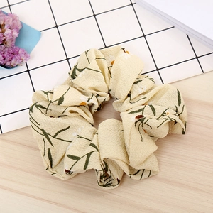 Detailed macro shot of floral print scrunchie with daisy pattern on wood background