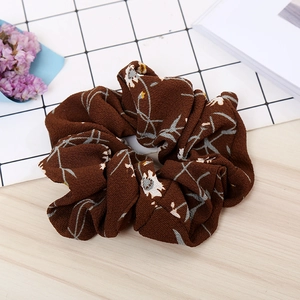 Close-up of dark brown floral scrunchie with detailed fabric texture and patterns