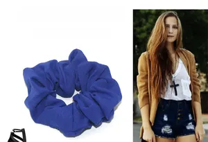 Detailed view of dark blue ruched oversized hair scrunchie with soft pleated fabric texture