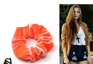 Dettaglio dell'elastico scrunchie in velluto arancione corallo e della sua consistenza