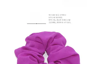 Detail shot of bright purple velvet scrunchie showing soft texture and pleated design