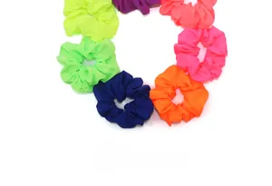 Close-up of vibrant neon elastic hair scrunchies set in various high-saturation colors