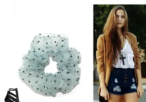 Detailed texture of light green polka dot tulle scrunchie with sheer ruffled mesh layers