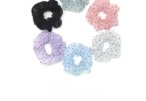 Detailed view of six colorful polka dot tulle scrunchies in organized ring layout