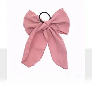 Close-up of a pink chiffon bow hair tie with delicate rolled edges and black elastic band