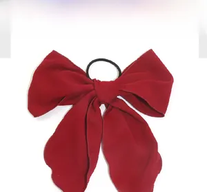 Detail of red bow hair tie made of matte fabric with high elasticity black rubber band