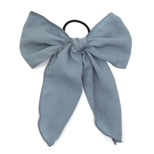 Elegant dusty blue bow hair scrunchie with long ribbons on a high elastic hair tie